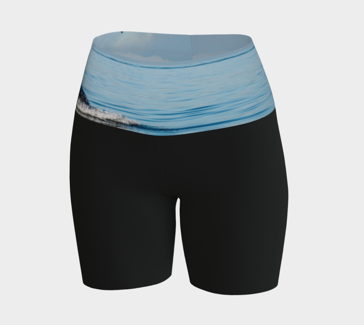 Orca Spray yoga shorts features a image of an orca exhaling on the ocean. This image is printed on the waistband and the rest of the shorts is black.
