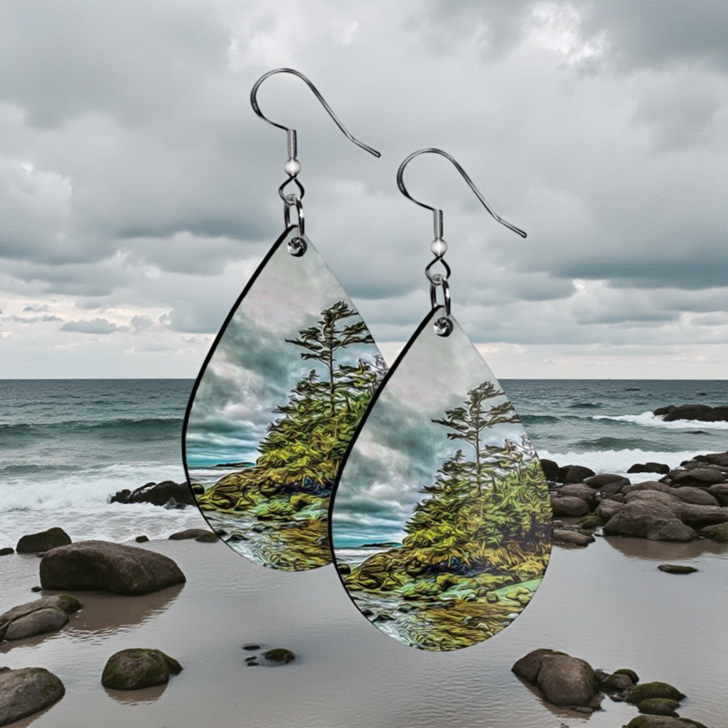 Teardrop-shaped earrings with nature-themed design against a beach background