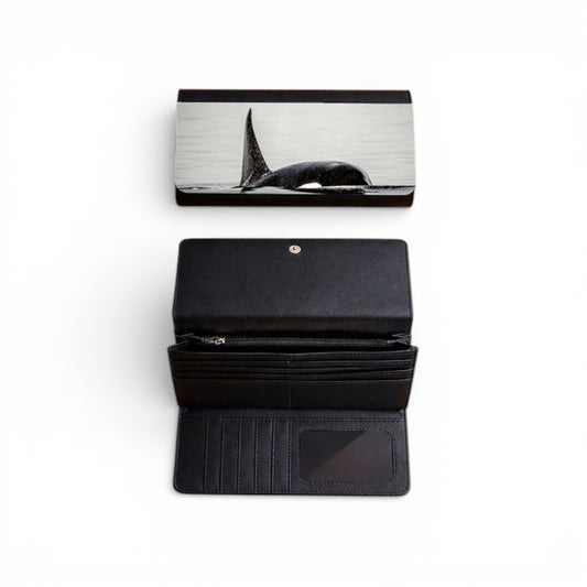 Black wallet with whale design on flap, open to show card slots and pocket.