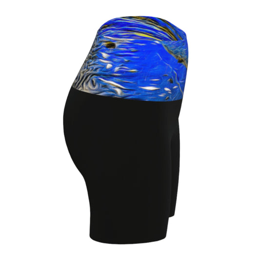 Right view Ebb and Flow Yoga shorts feature a image of the ocean water at low tide with the sky and the sun reflecting on the water. This image is printed on the band of the yoga shorts. The bottom of the shorts are black.