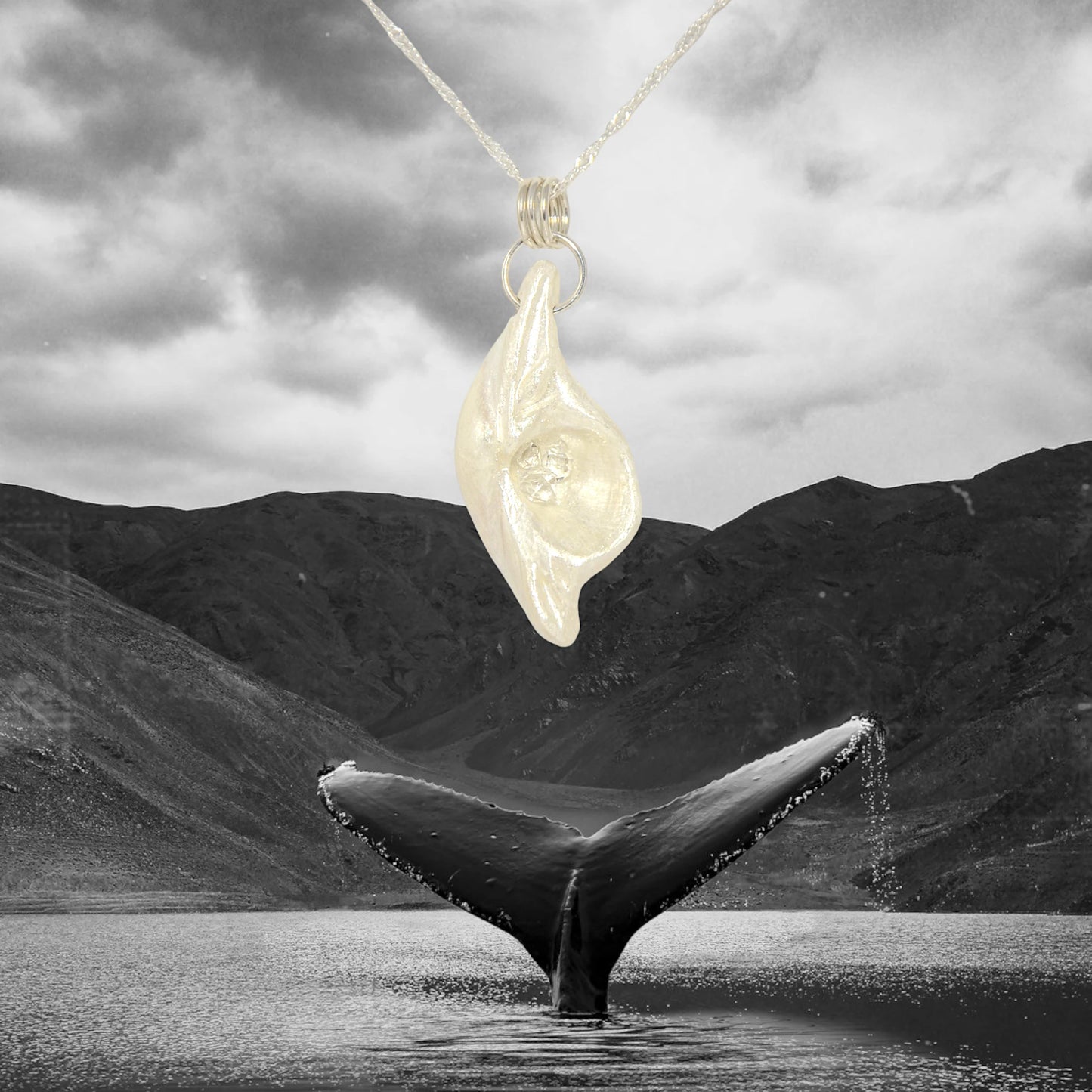 Halo natural seashell pendant with three herkimer diamonds. The pendant is shown with mountains, ocean and a whale tail. 