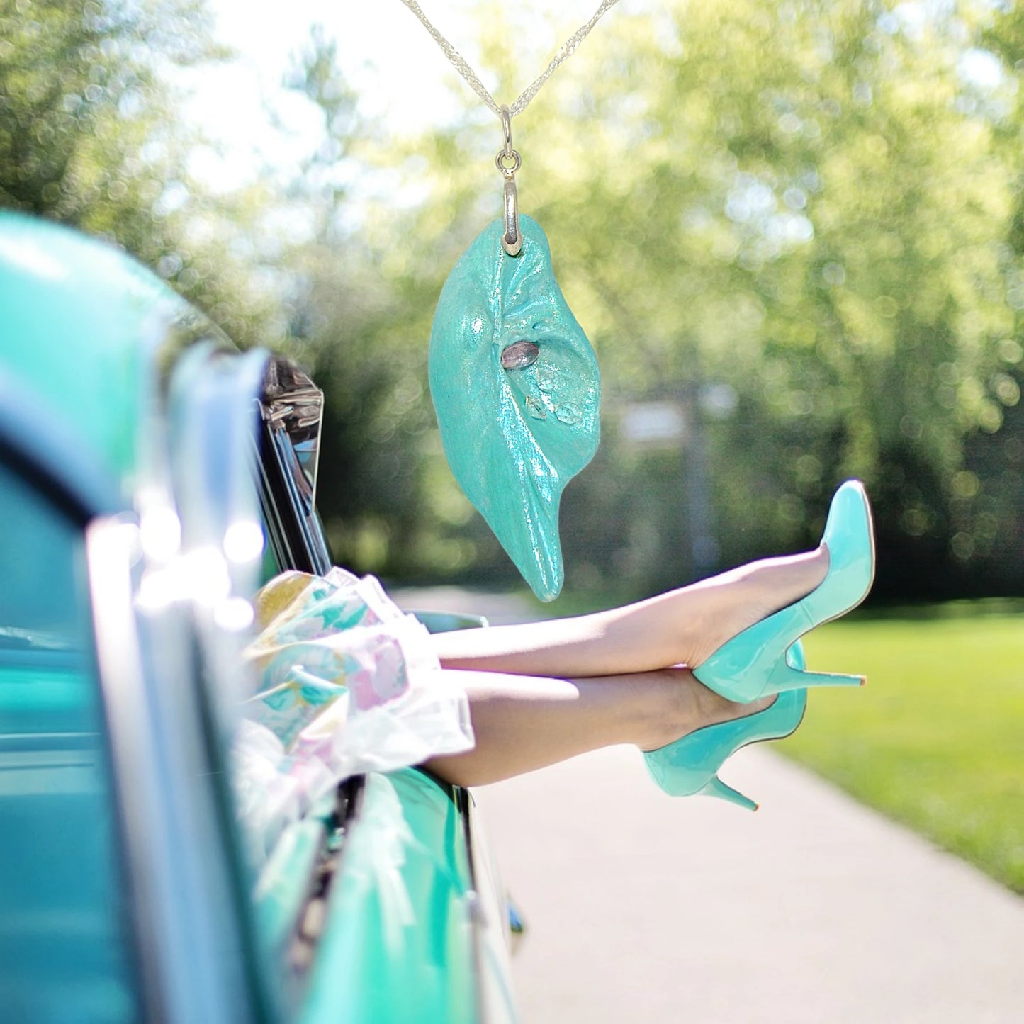 Violet Light is a natural seashell pendant with a rose cut Amethyst Gemstone and three Herkimer diamonds. A woman with turquoise high heel shoes outside of a old car.