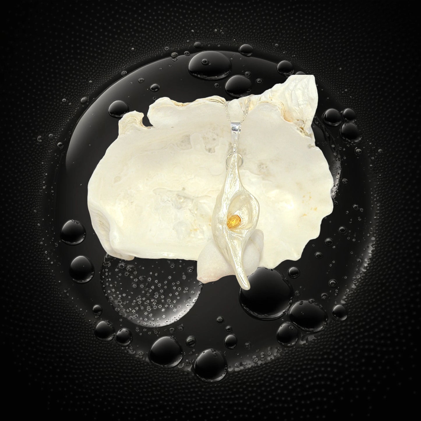 Lightmaker natural seashell pendant A beautiful pear shaped rose cut Citrine compliments the pendant. The pendant is displayed in front of a larger seashell. the background is black water bubbles.
