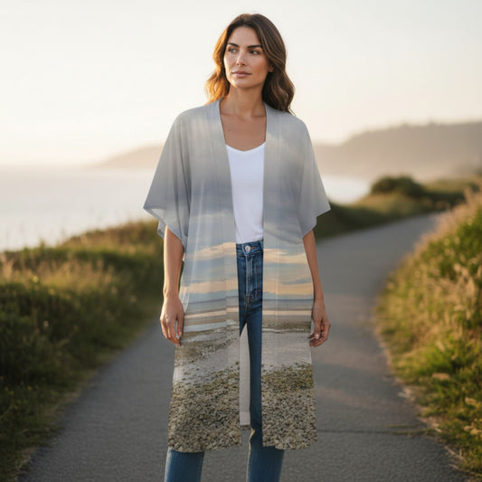 Woman wearing a long, patterned kimono-style garment on a scenic path.