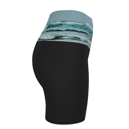 Ocean Calling Long Beach Tofino Yoga shorts. The image of the ocean waves is printed on the waistband. The rest of the shorts is black.
