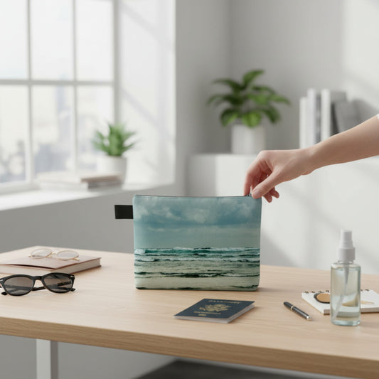 Hand reaching for a laptop with a scenic design on a desk in a bright room.