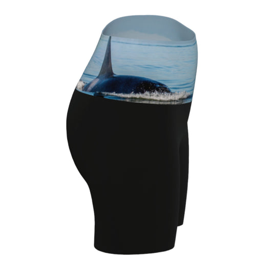 Orca Spray yoga shorts features a image of an orca exhaling on the ocean. This image is printed on the waistband and the rest of the shorts is black.