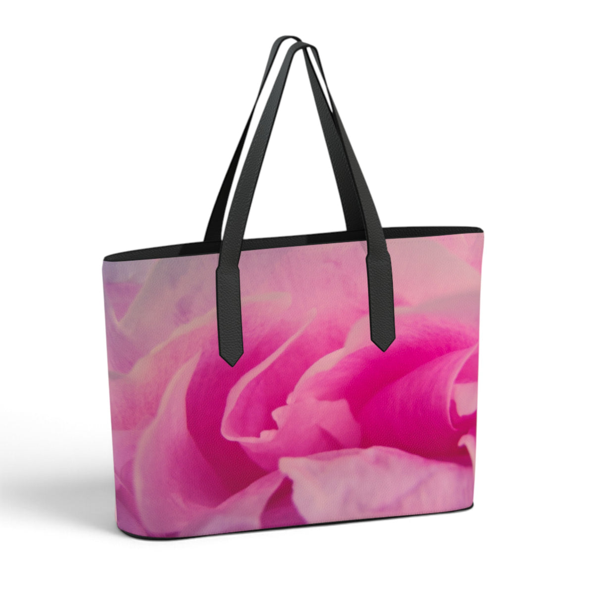 A tote bag featuring a vibrant pink rose print on the front, with black shoulder straps and black trim, shown against a plain white background.