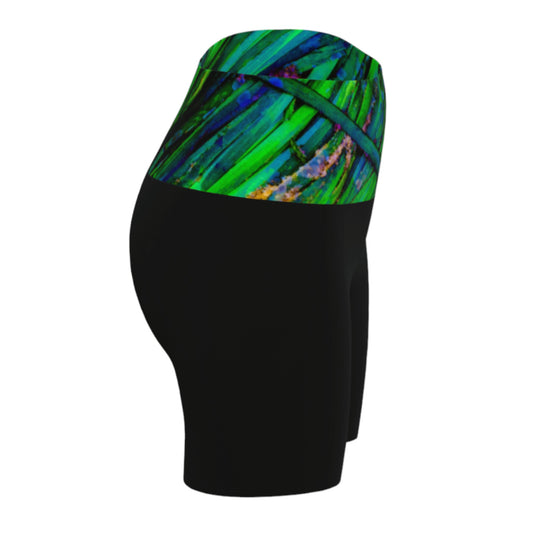 Shades of green yoga shorts features the image of spring green ocean sea grass at low tide. the rest of the shorts are black.
