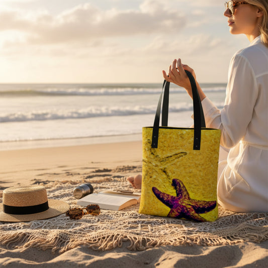 Woman holding a tote bag with a starfish design on a beach