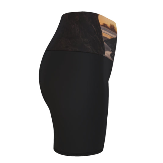 Tofino Sunset Yoga Shorts features an image of a sunset at long beach tofino printed on the waistband. the rest of the shorts are black.