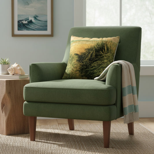 An olive green upholstered armchair with wooden legs, styled in a bright living room with a beach-themed throw pillow and a striped throw blanket draped over the arm.