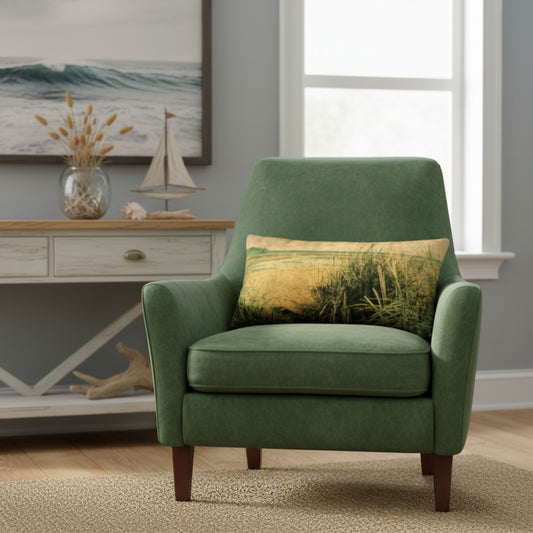 A green upholstered accent chair with dark wood legs, styled in a coastal-themed room with a matching green pillow featuring a beach grass print, set in front of a console table and window.