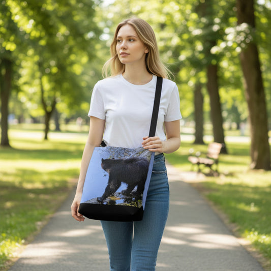 Woman walking in a park holding a tote bag with a bear design.