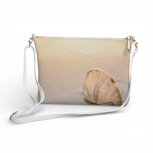 Van Isle Goddess sand dollar vegan leather crossbody purse with adjustable white strap and gold hardware.