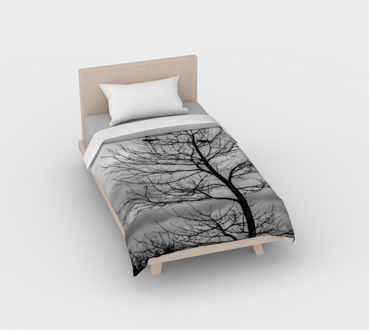 Cotton duvet cover on a queen sized bed. The image on the duvet cover is that of Blackbirds such as a crow perched in a tree.
