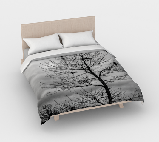 Cotton duvet cover on a queen sized bed. The image on the duvet cover is that of Blackbirds such as a crow perched in a tree.