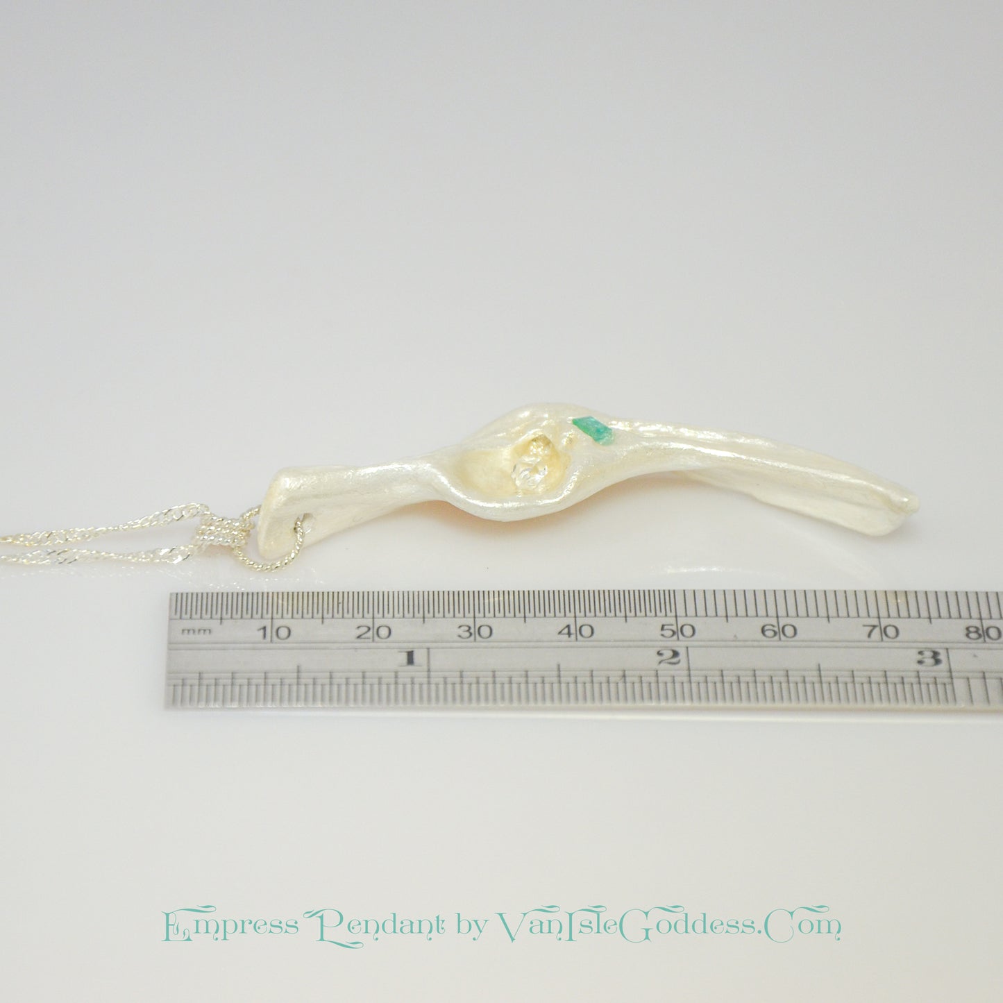 Empress natural seashell pendant with a Herkimer Diamond and Emerald. The pendant is shown laying down along a ruler so the viewer can see how long the pendant is.
