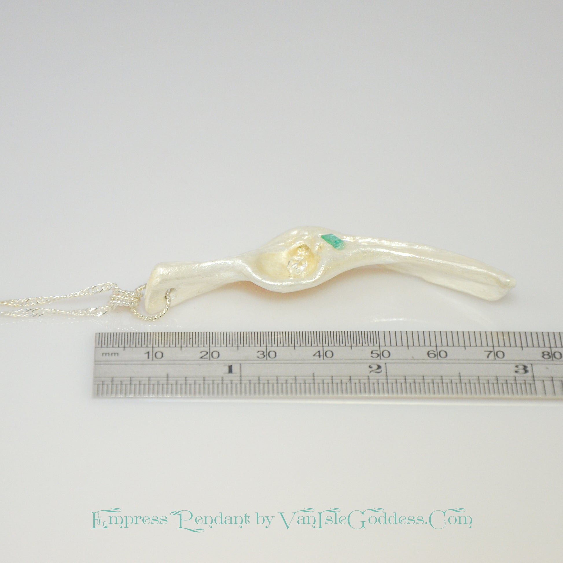Empress natural seashell pendant with a Herkimer Diamond and Emerald. The pendant is shown laying down along a ruler so the viewer can see how long the pendant is.