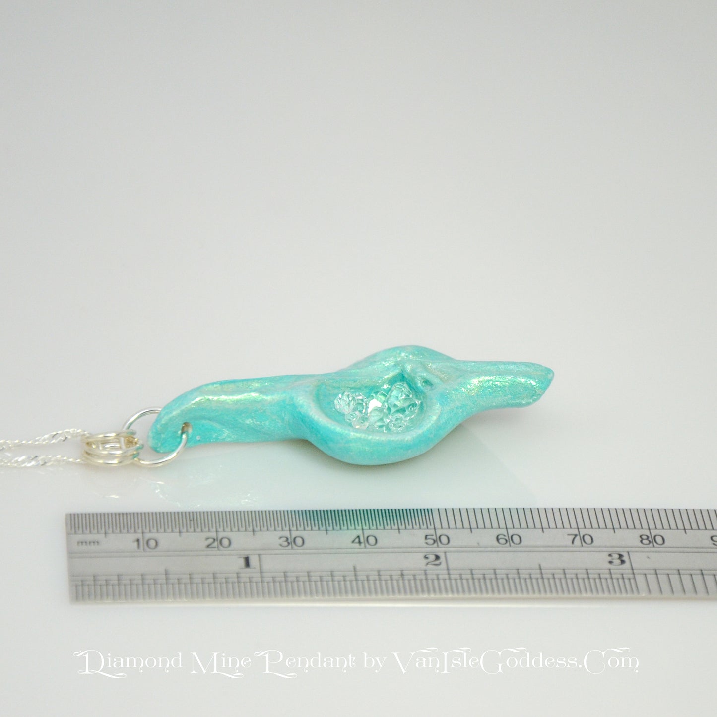Diamond Mine Pendant is named for the eight herkimer diamonds that enhance the beauty of this gorgeous pendant! The pendant is shown laying down along a ruler so the viewer can see the length of the pendant.