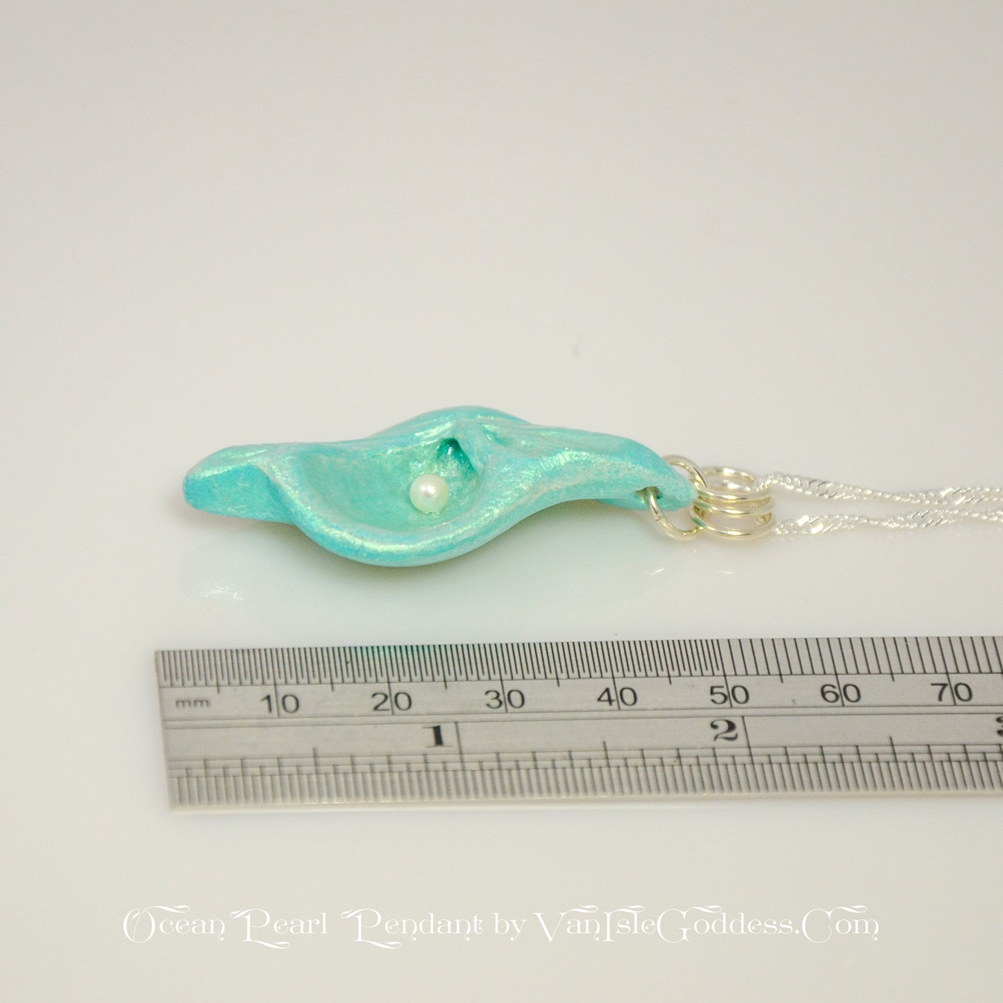 Ocean Pearl natural seashell pendant has a real freshwater baby pearl. The pendant is shown along side a ruler so the viewer can see how long the pendant is.