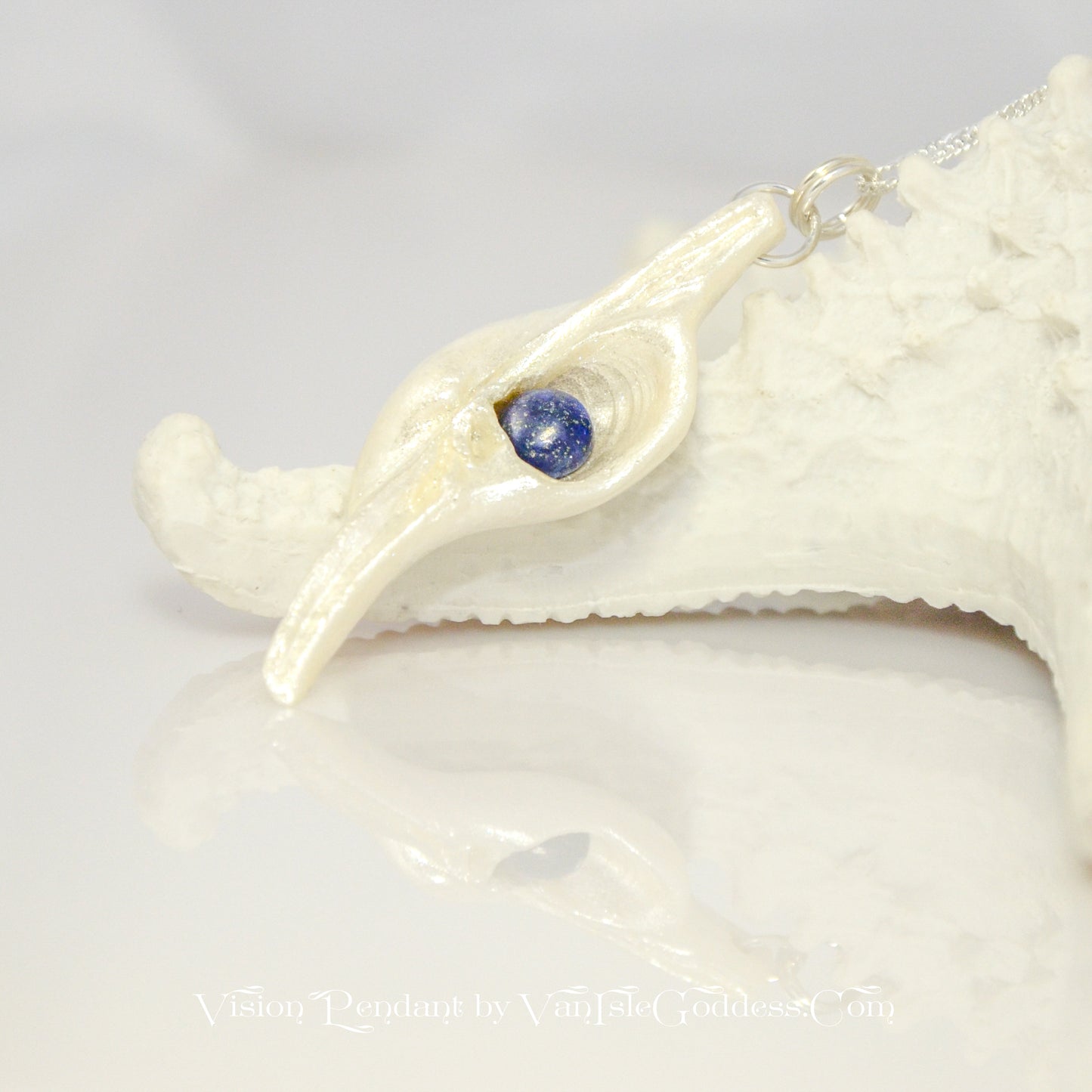 Vision is a natural seashell pendant with a Lapis Lazuli gemstone.