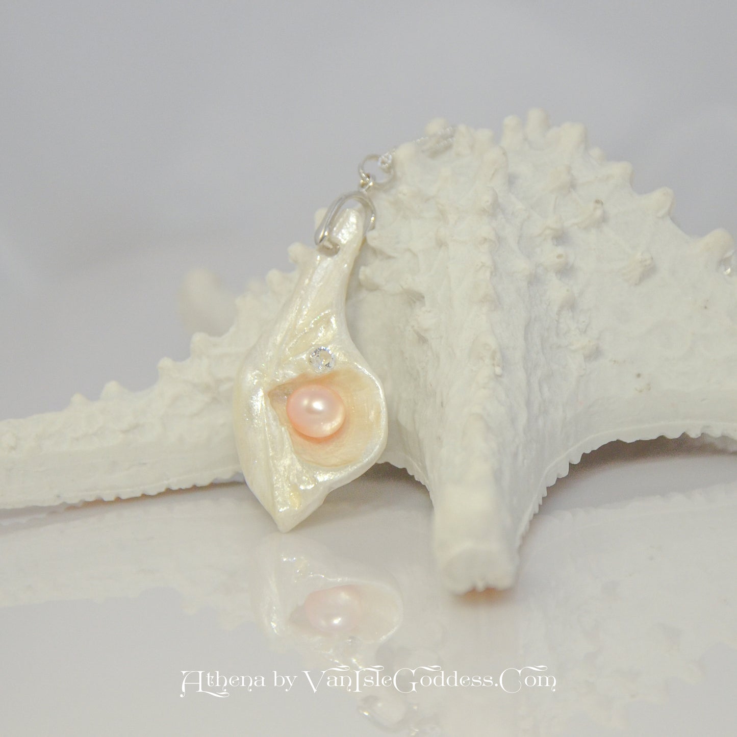 Natural Seashell Pendant with freshwater pearl and faceted herkimer diamond. The pendant is leaning on a starfish.