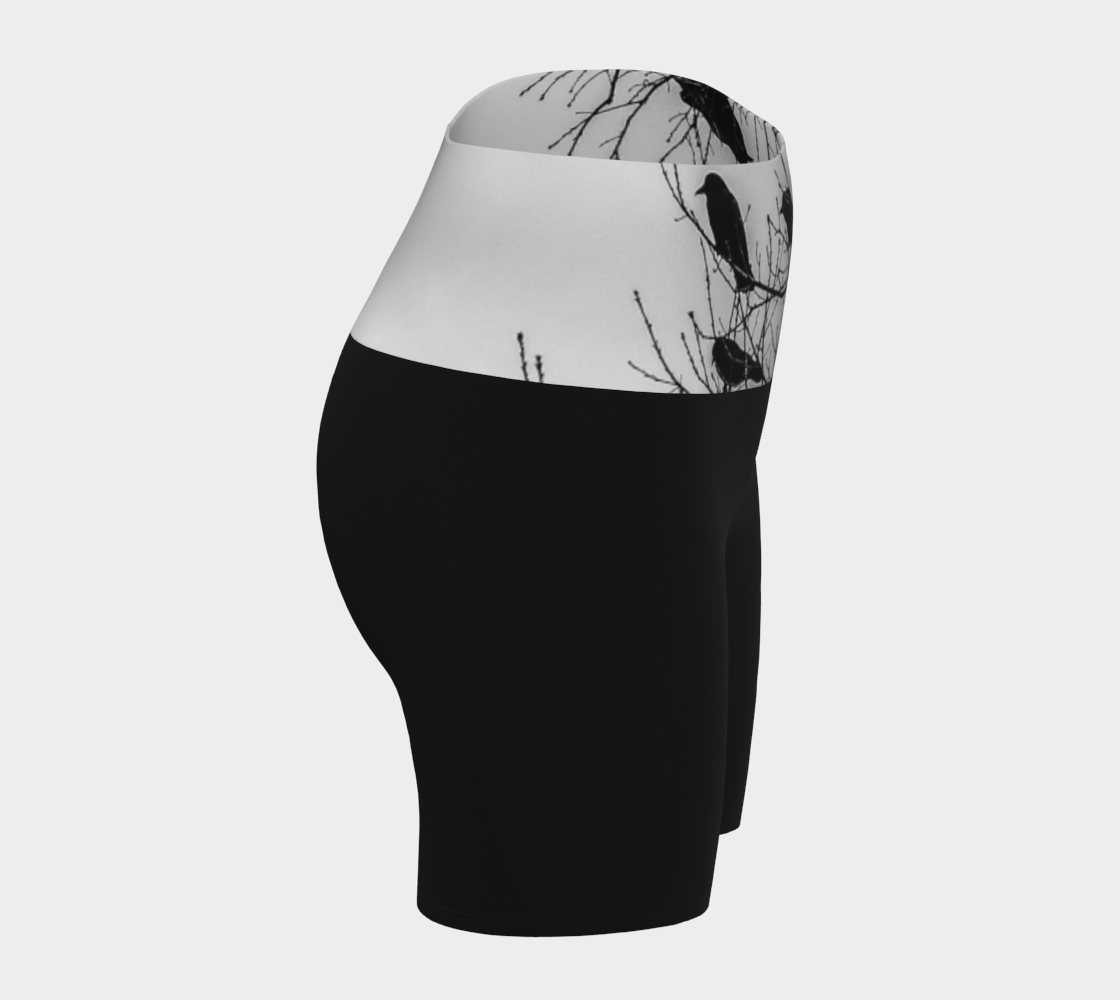 Crows Yoga Shorts feature a photograph of crows sitting in a tree printed on the band of the yoga shorts. The bottom of the yoga shorts are black.