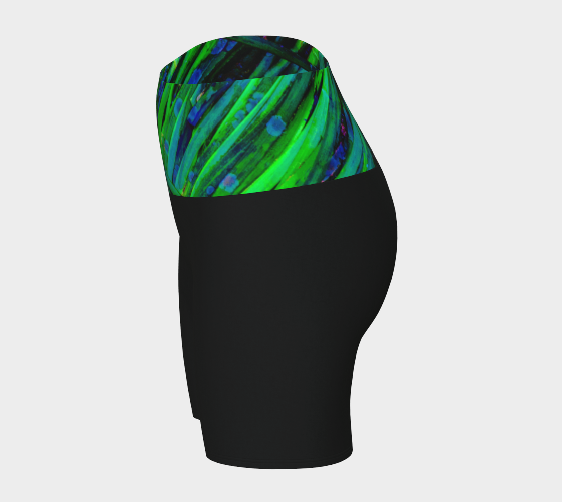 Shades of green yoga shorts features the image of spring green ocean sea grass at low tide. the rest of the shorts are black.