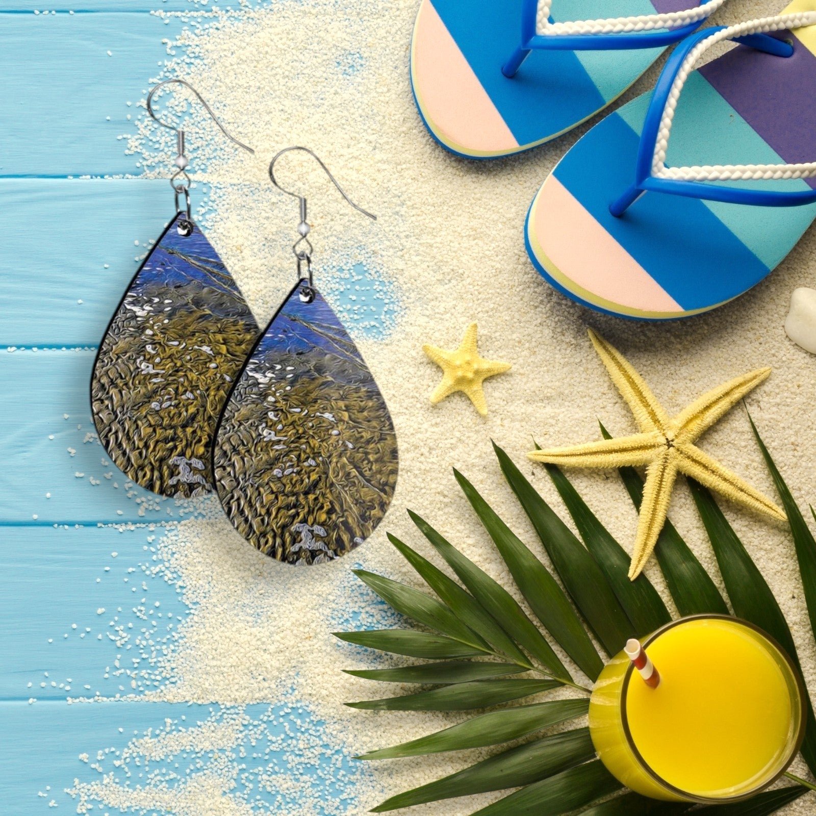 Teardrop-shaped earrings on a beach-themed background with flip-flops, starfish, and a drink.