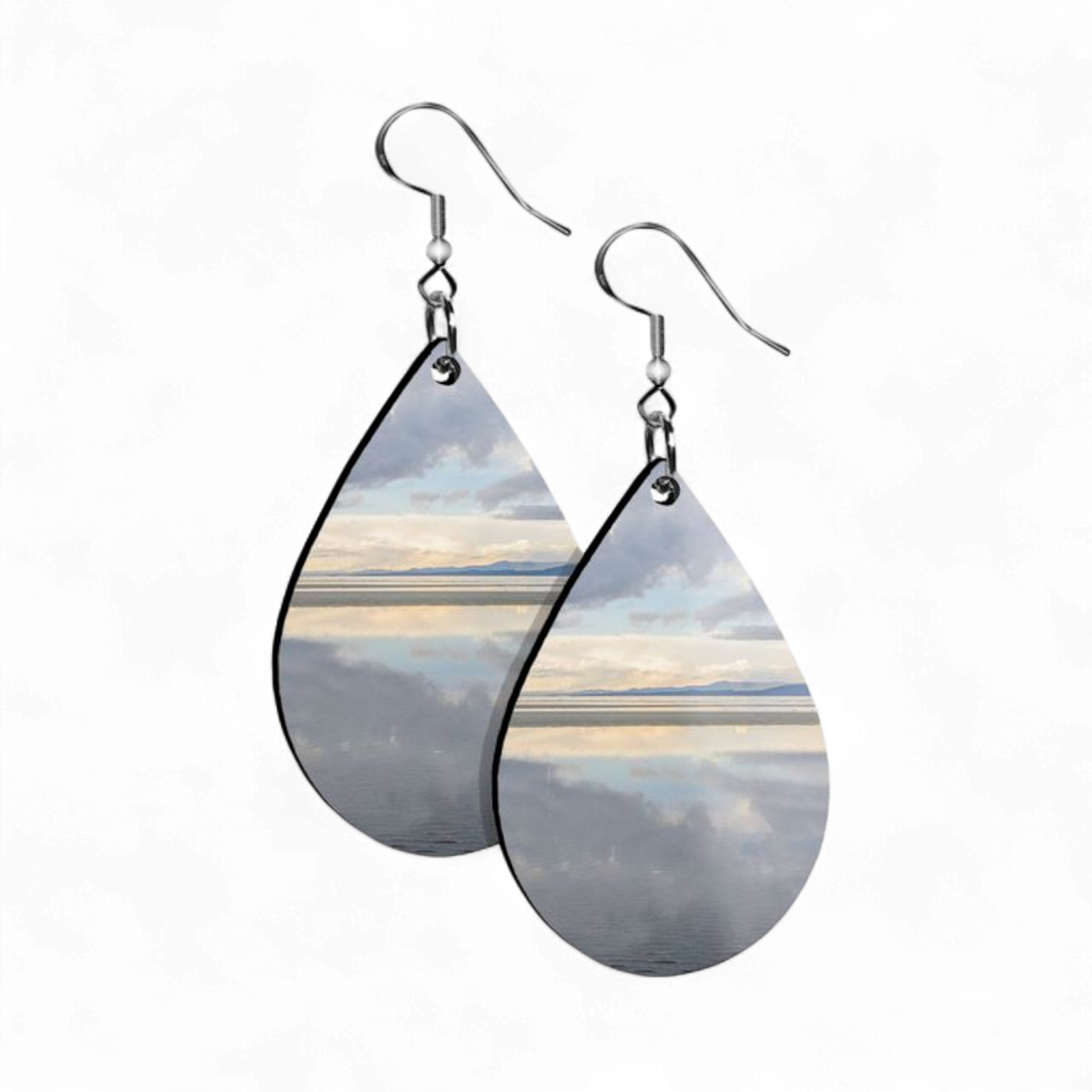 Beach image printed on pair of earrings with white background.