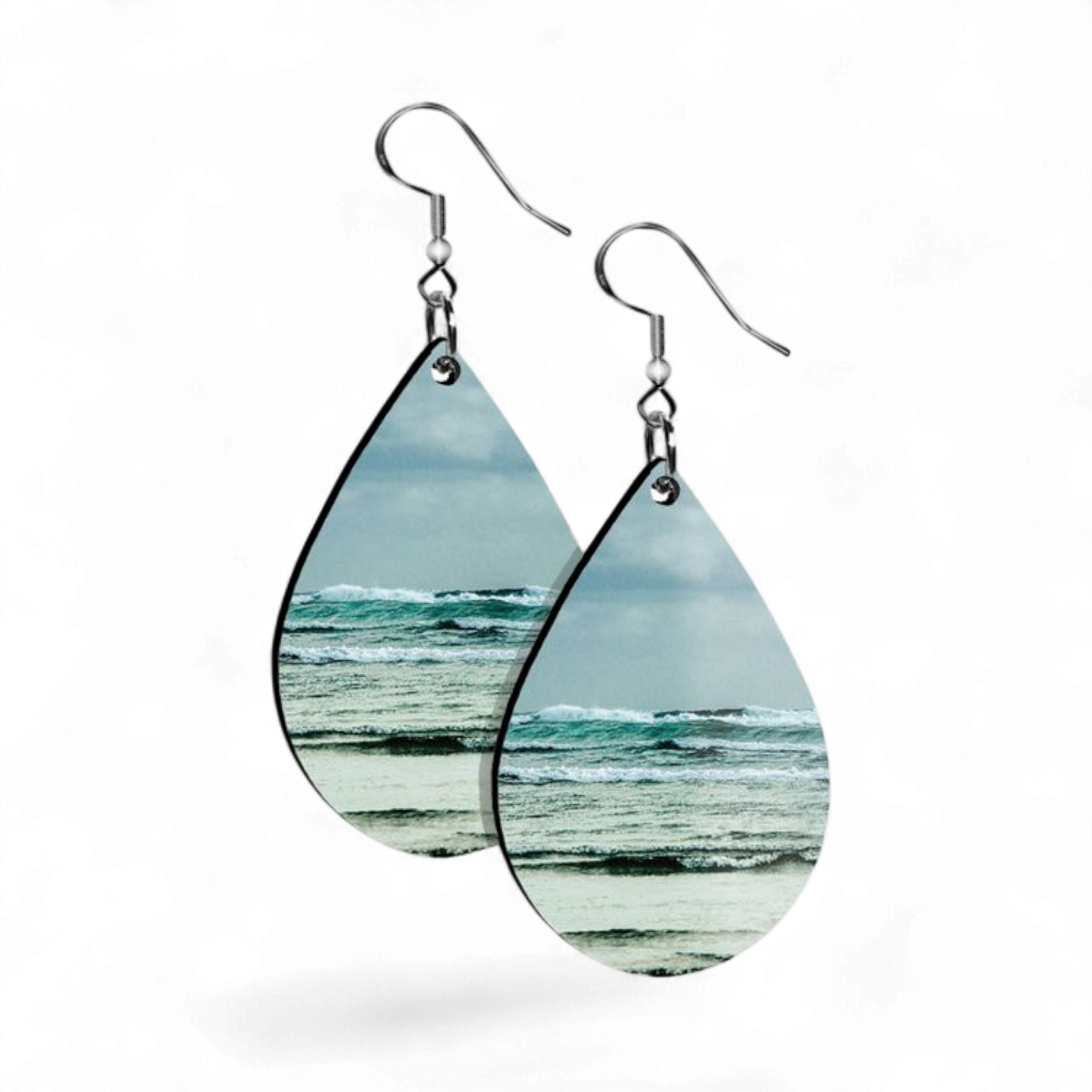 Teardrop-shaped earrings with ocean view design on a white background