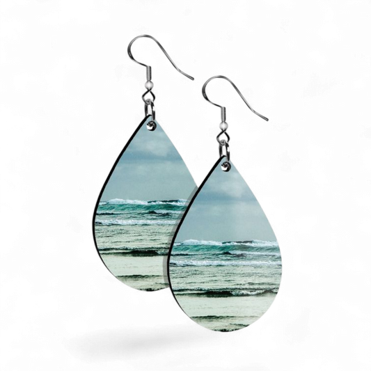 Teardrop-shaped earrings with ocean view design on a white background