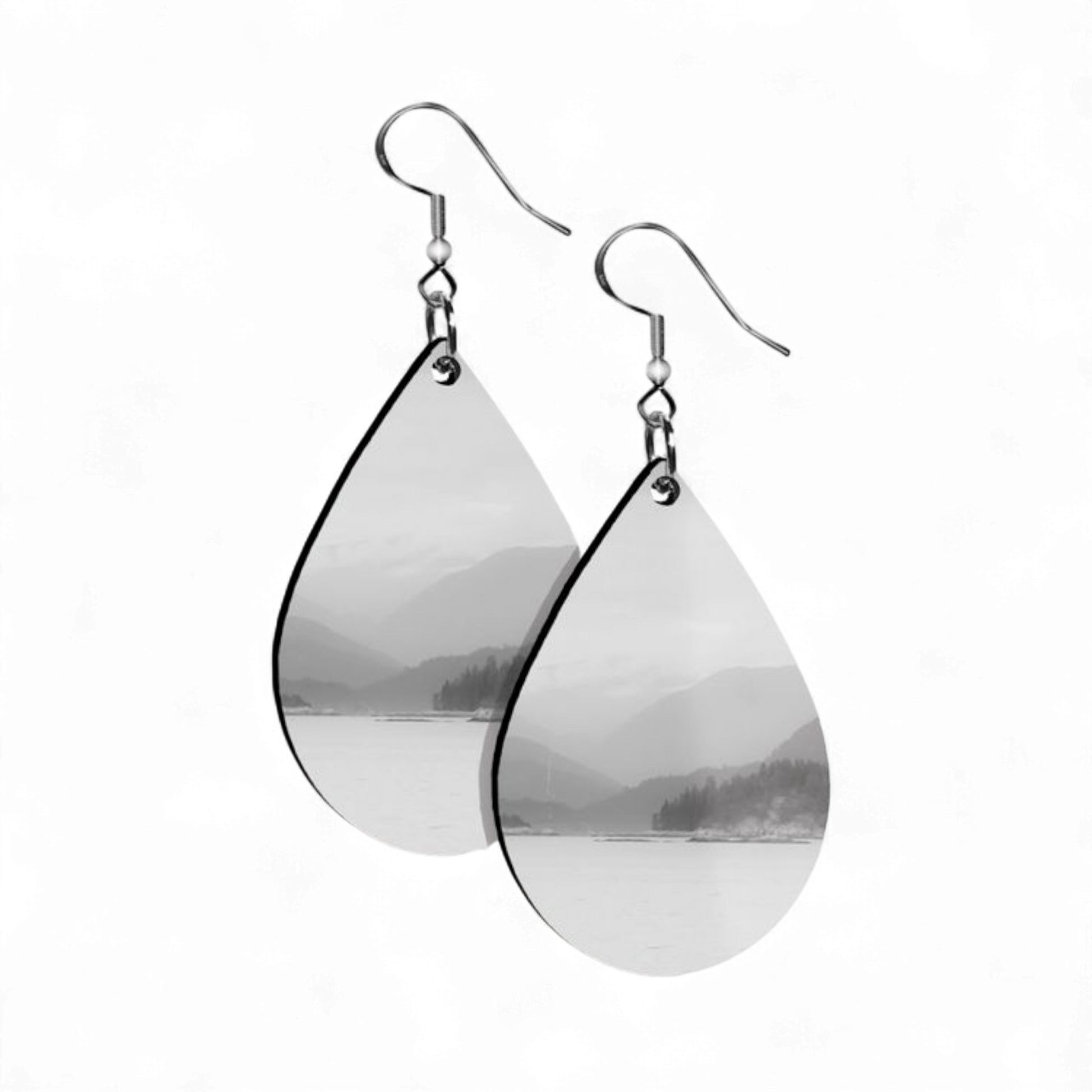 Teardrop-shaped earrings with mountain and lake scene on a white background