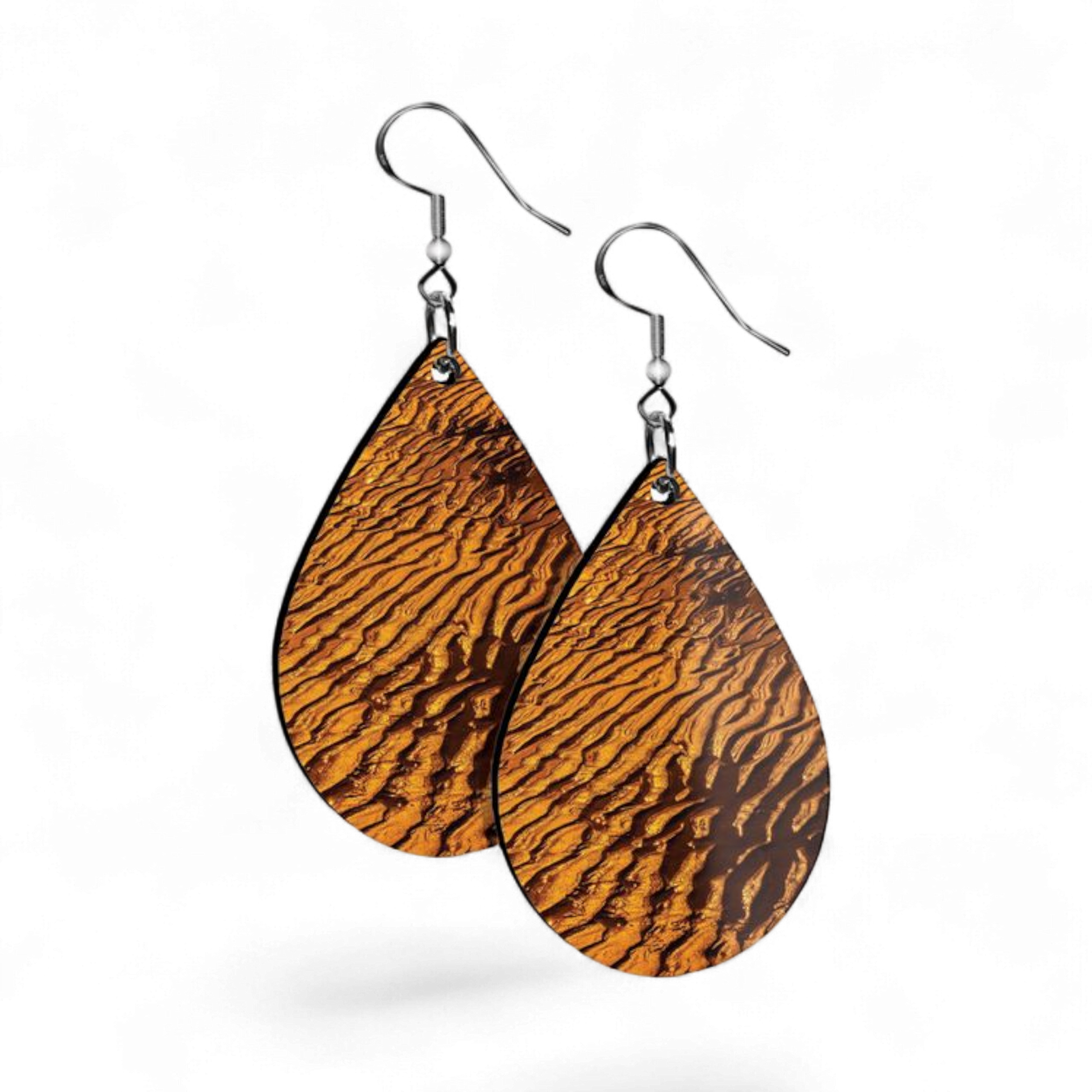 Teardrop-shaped earrings with sand stripe pattern on a white background