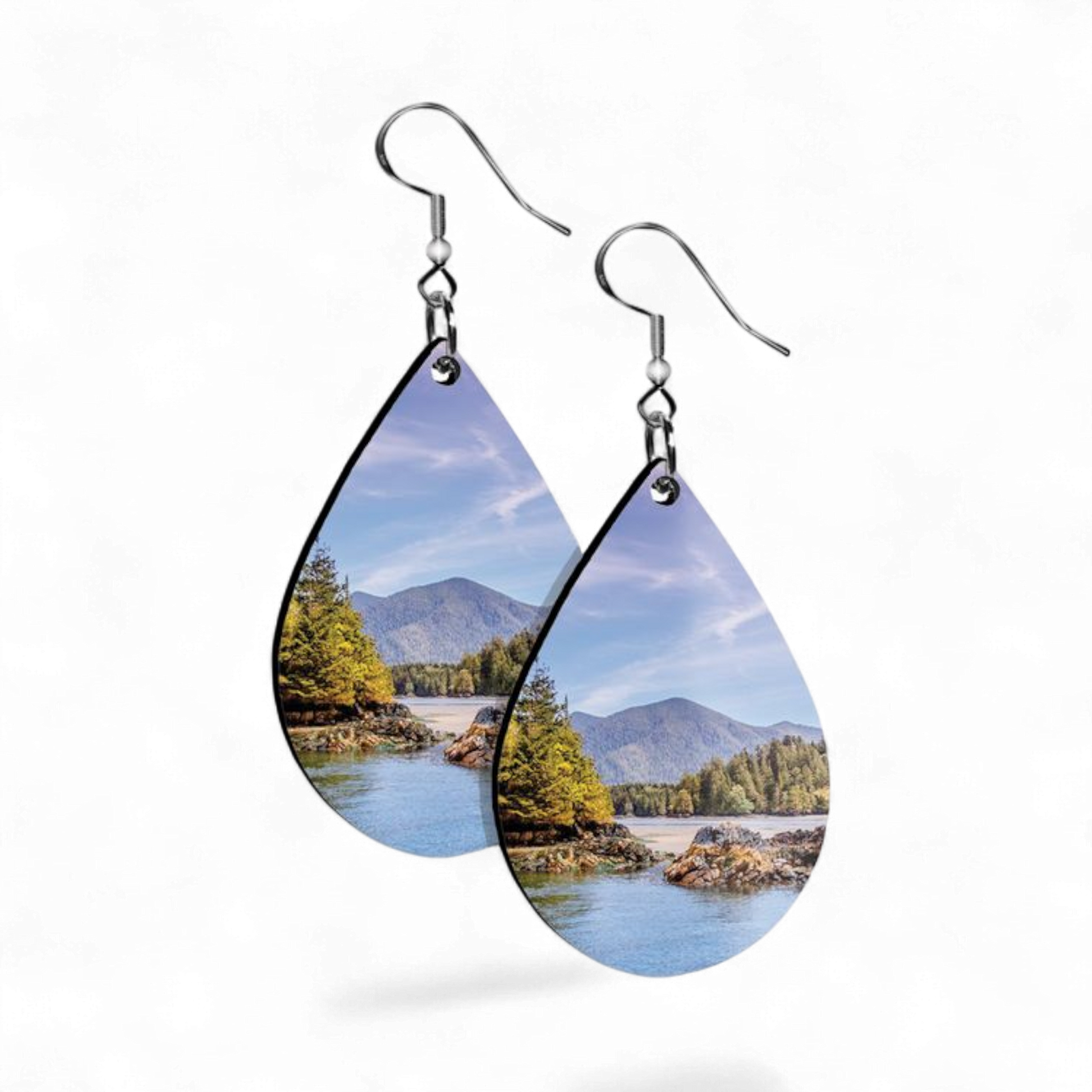 Teardrop-shaped earrings with nature scene design on a white background