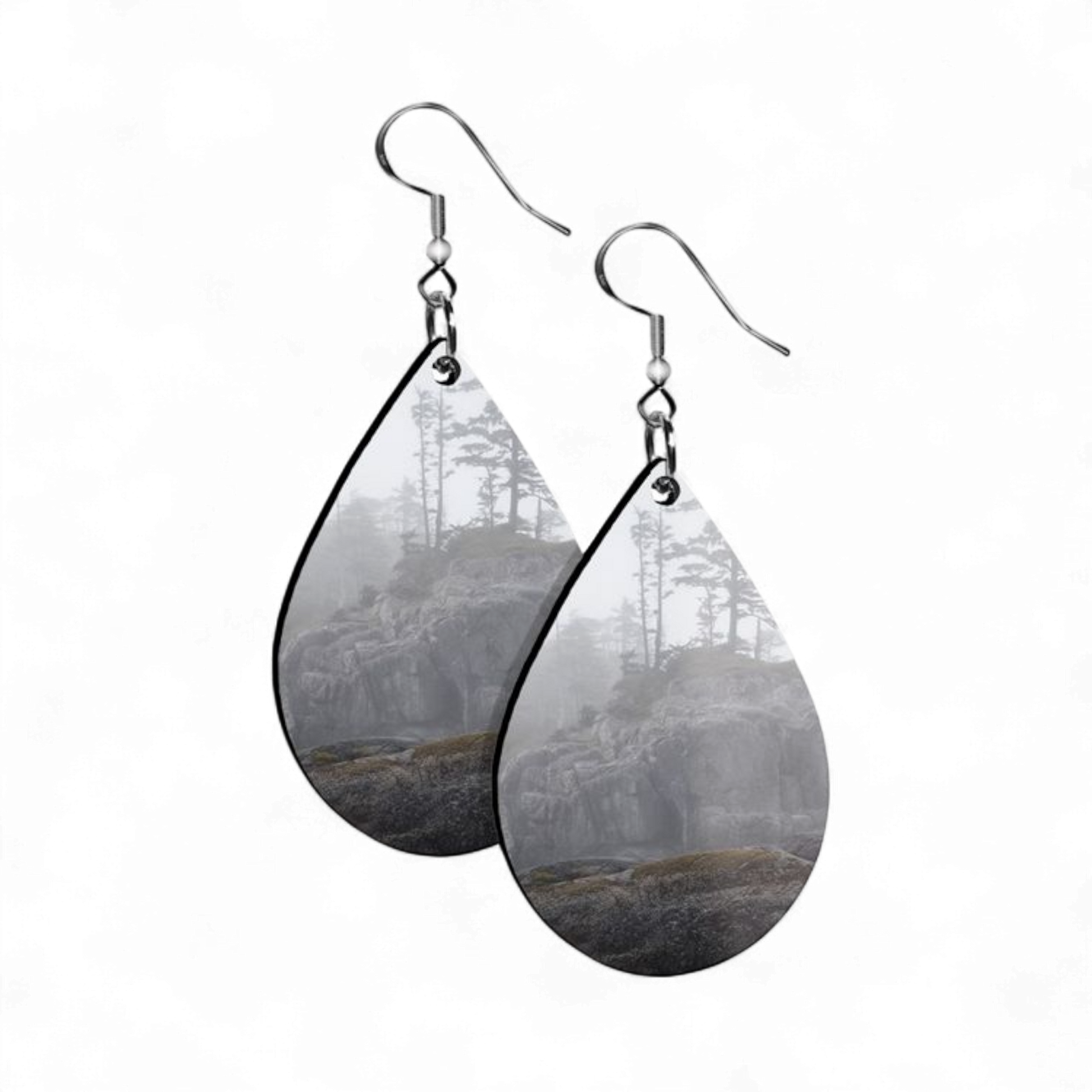 Teardrop-shaped earrings with forest design on a white background