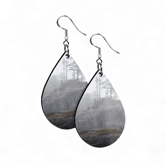 Teardrop-shaped earrings with forest design on a white background