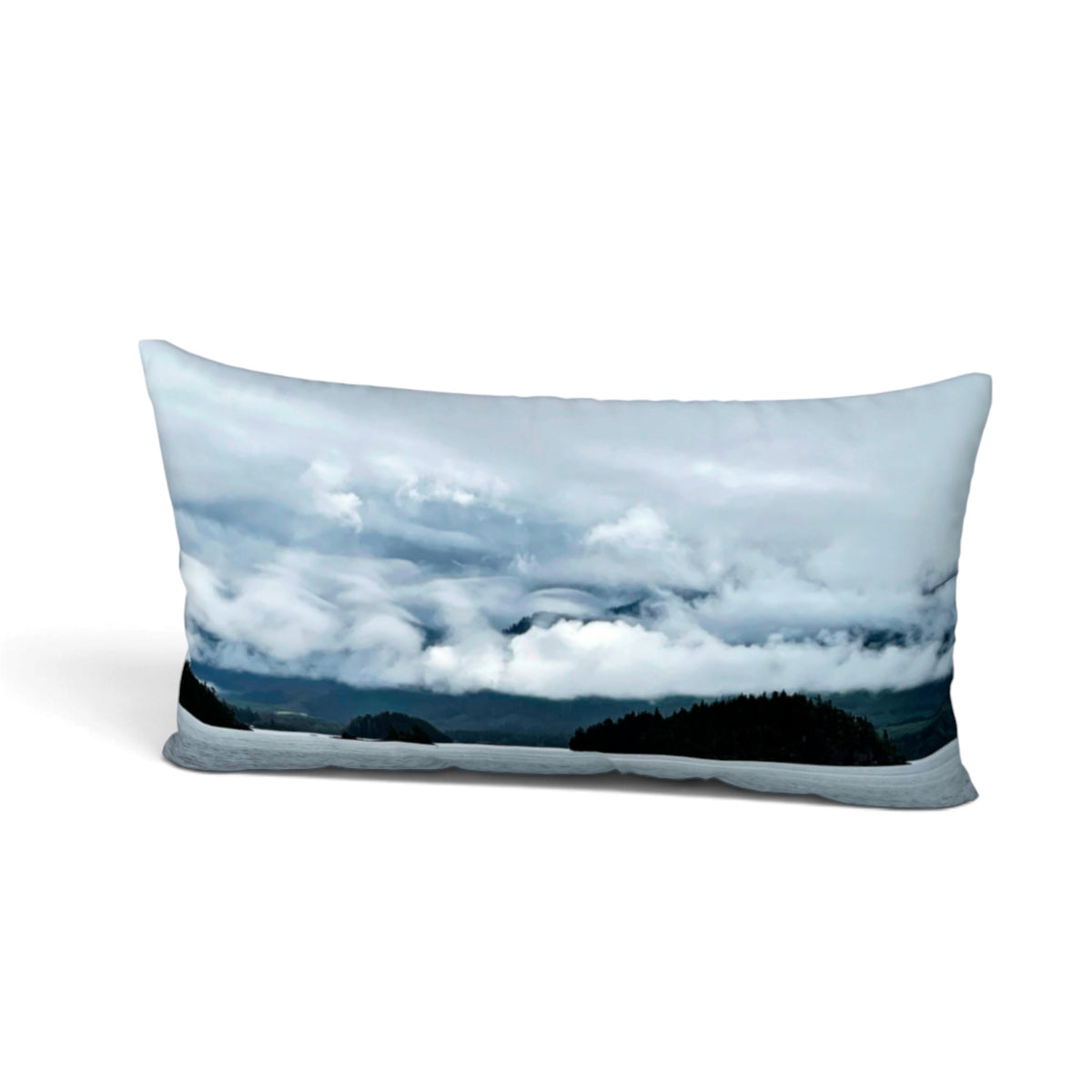 A rectangular lumbar pillow featuring a photographic print of a dramatic cloudy sky over dark forested hills, shown on a clean white background.