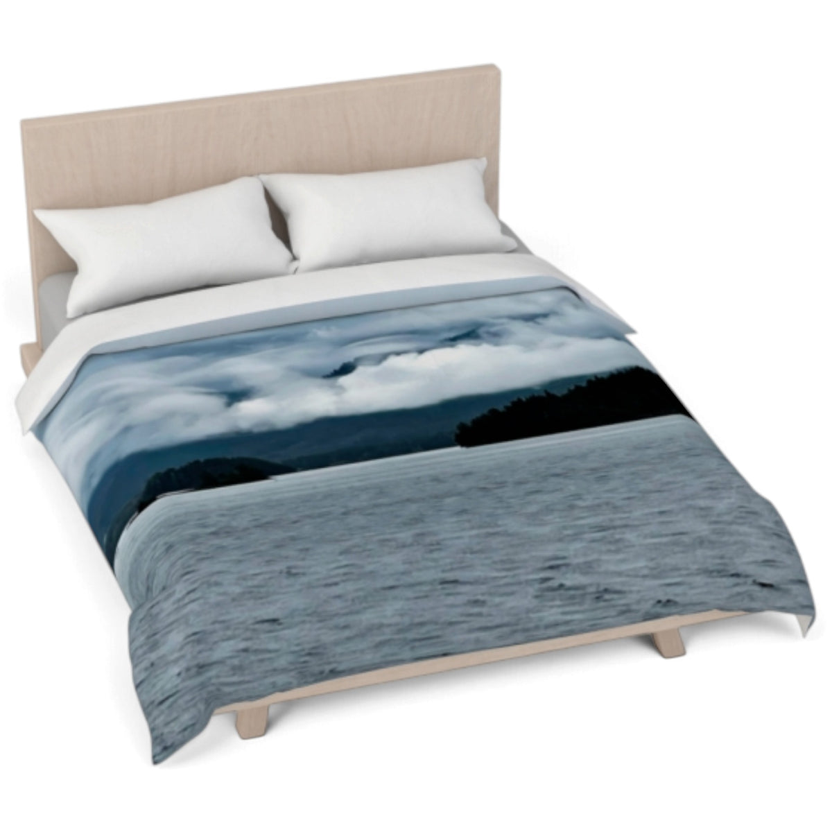 A bed dressed with a duvet cover featuring a scenic landscape print of blue water, dark land, and cloudy sky, styled with two white pillows on a light wood bed frame against a white background.