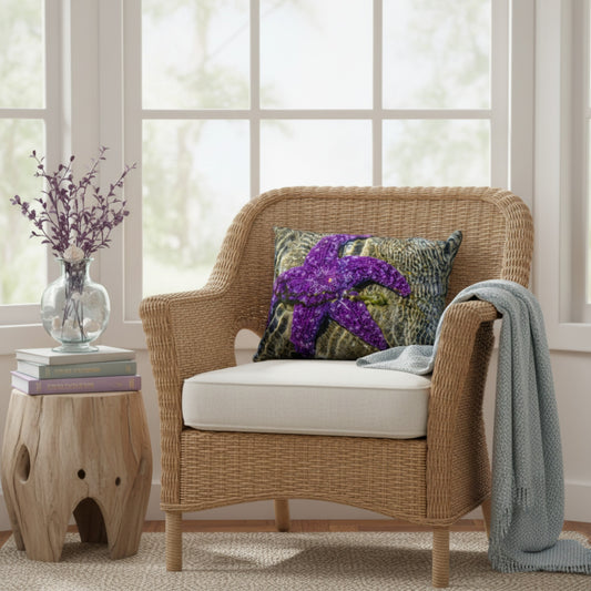 Pillow with a starfish on it set on a rattan chair in front of window.