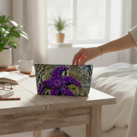Person placing a pouch with a purple starfish design on a wooden table in a bright room.