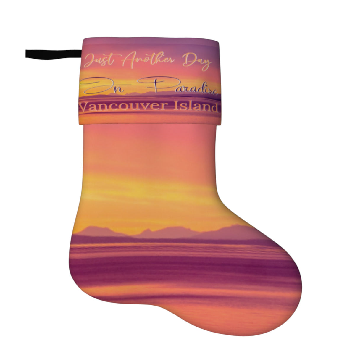 A Christmas stocking featuring a scenic sunset landscape print with purple mountains, orange and yellow sky, and the text 'Just Another Day On Vancouver Island' on a purple cuff.
