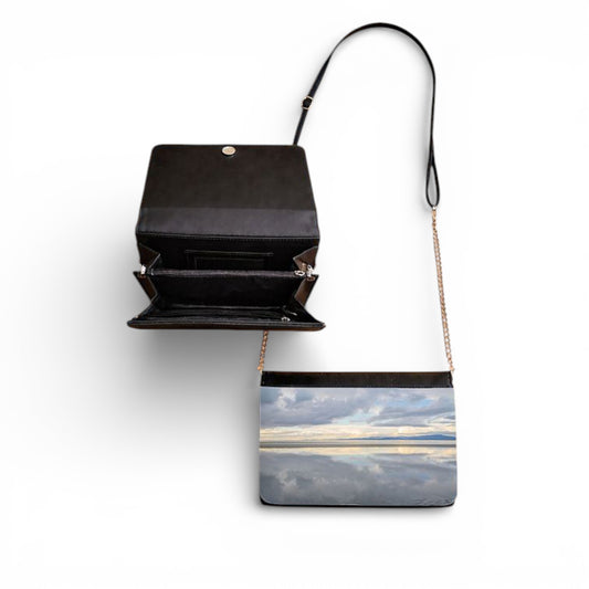 Black handbag with a scenic design on a white background