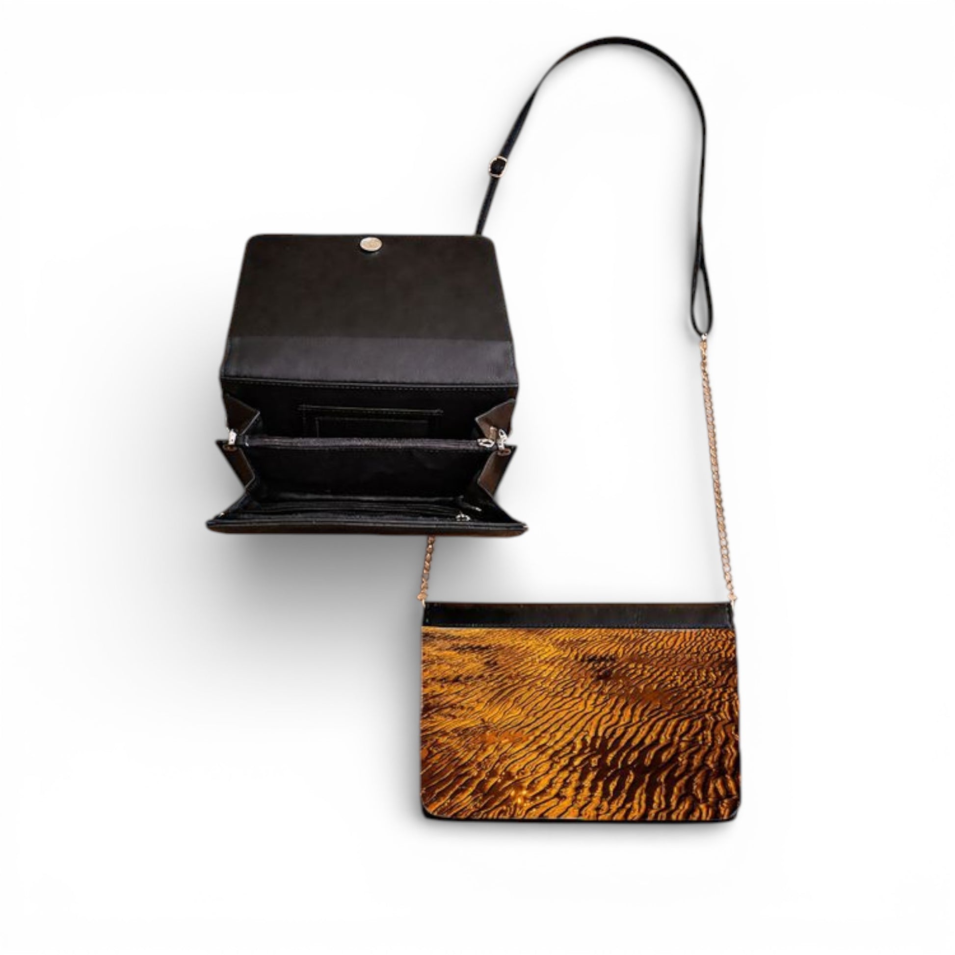 Black handbag with a brown sand at sunset on a white background