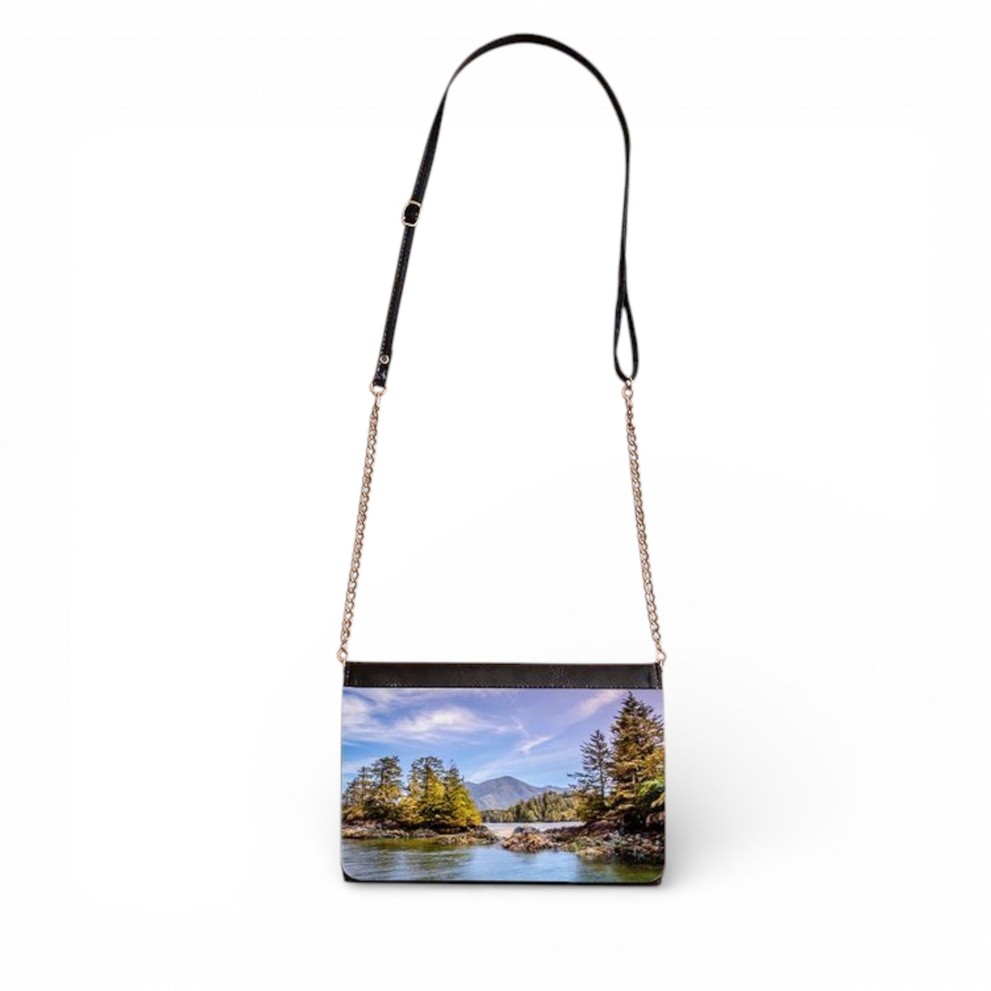 Crossbody bag with a scenic print of a ocean and trees on a white background