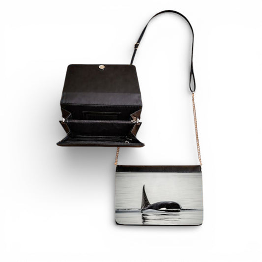 Black handbag with whale design on a white background
