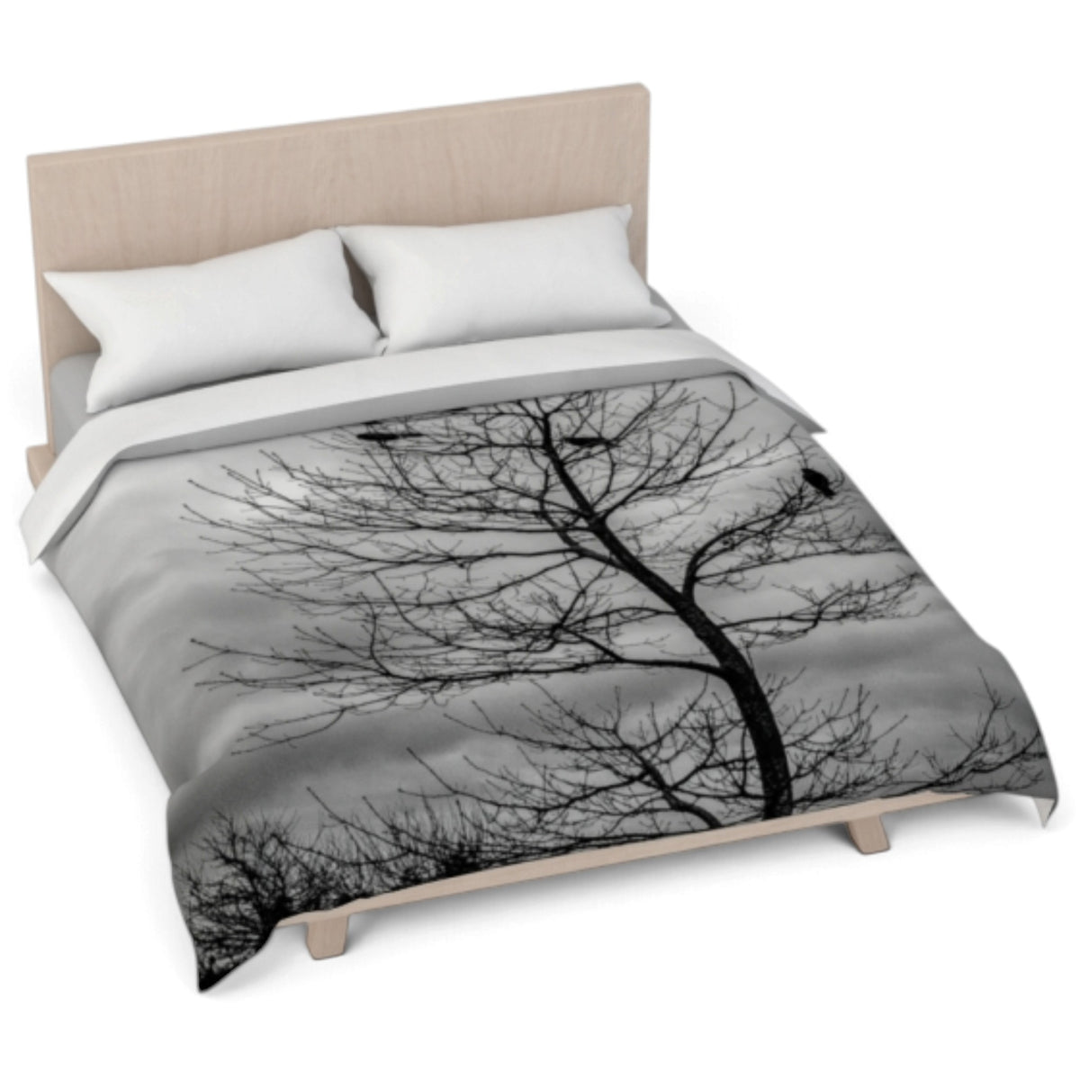 A bed dressed with a duvet cover featuring a black-and-white tree silhouette print, shown with two white pillows and a light wood headboard on a white background.