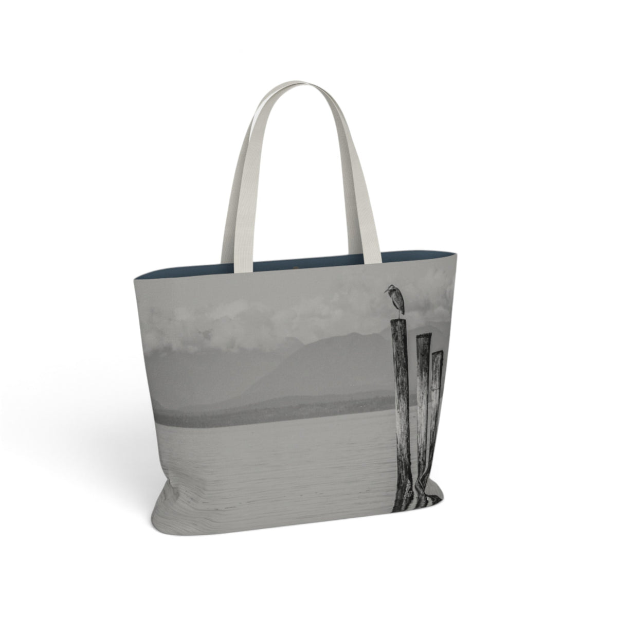 A tote bag featuring a grayscale landscape photograph of a lake and wooden posts, with light gray fabric handles, shown on a plain white background.