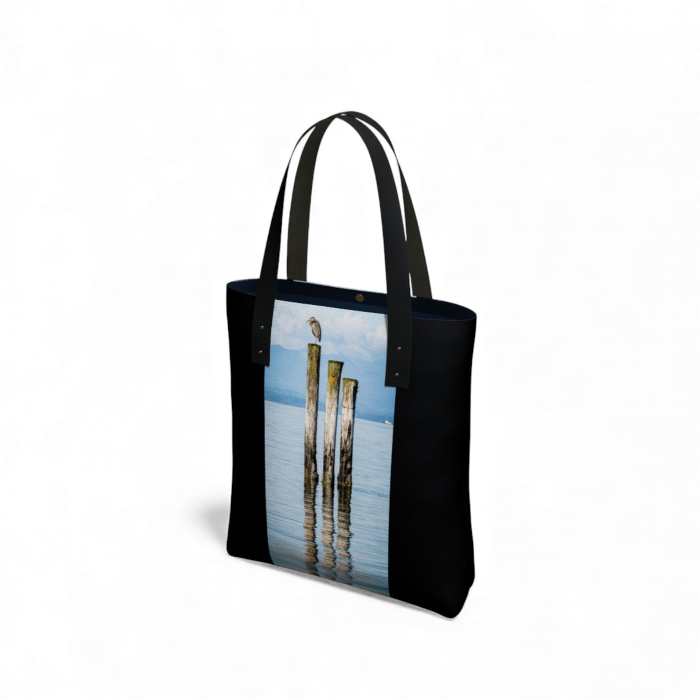 Black tote bag with a scenic print of poles and water on a white background
